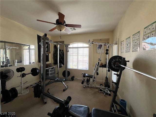 exercise room with visible vents, baseboards, and ceiling fan
