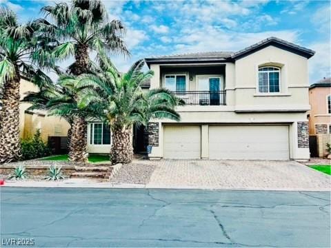 7109 Rancho De Taos, Las Vegas, NV 89130 - view of front facade with a balcony, stucco siding, an attached garage, and driveway