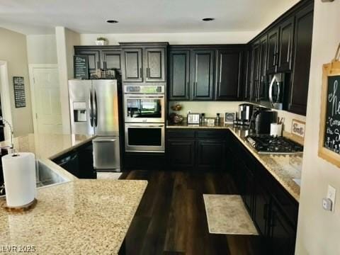 7109 Rancho De Taos, Las Vegas, NV 89130 - kitchen featuring stainless steel appliances, dark cabinets, light stone counters, and dark wood-type flooring