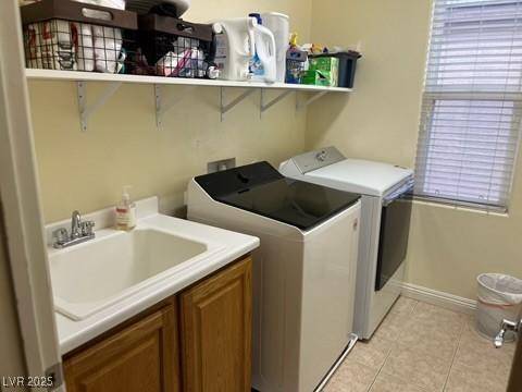 7109 Rancho De Taos, Las Vegas, NV 89130 - laundry room with washing machine and clothes dryer, cabinet space, light tile patterned floors, and baseboards
