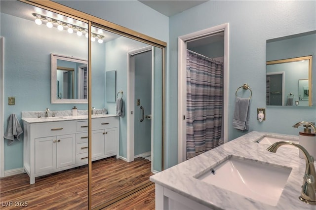 bathroom featuring vanity, baseboards, wood finished floors, and a shower with shower curtain