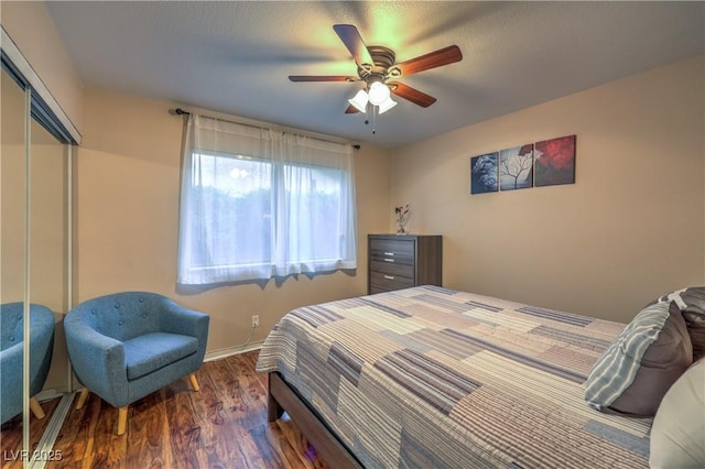 bedroom featuring baseboards, a ceiling fan, a closet, and wood finished floors