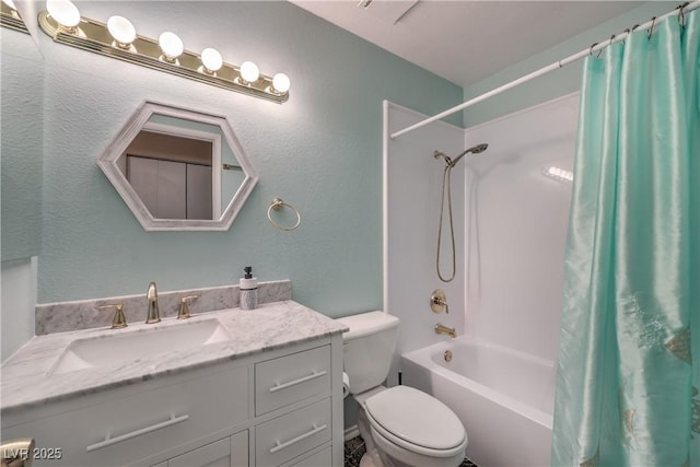 full bathroom featuring vanity, a textured wall, shower / bath combo, and toilet