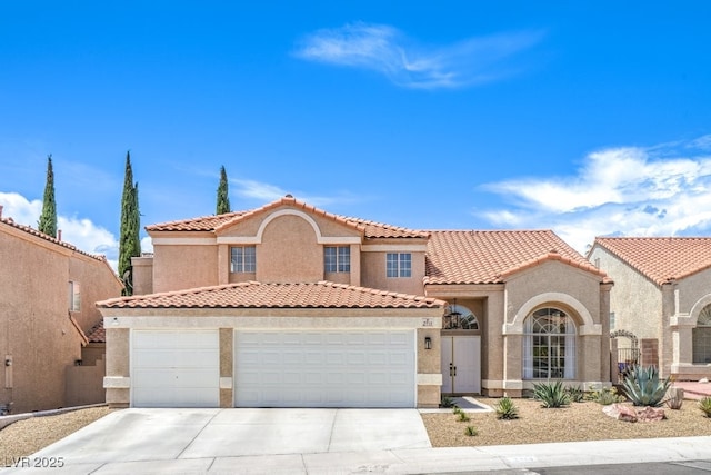 mediterranean / spanish-style house featuring stucco siding, driveway, a tile roof, and a garage