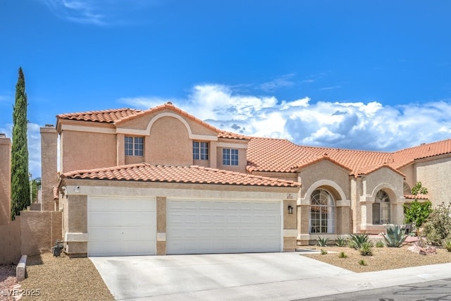 mediterranean / spanish-style house featuring an attached garage, stucco siding, a tiled roof, and concrete driveway