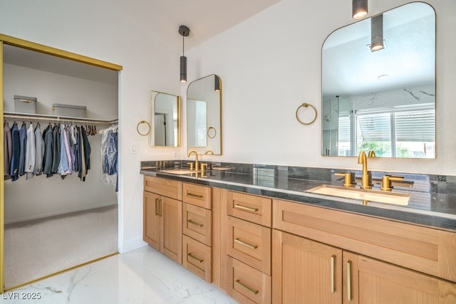 bathroom featuring double vanity, a sink, marble finish floor, and a spacious closet