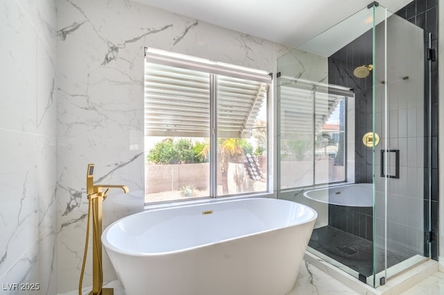 bathroom with a soaking tub, a stall shower, stone wall, and marble finish floor