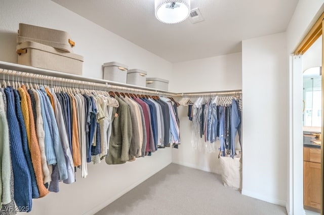 walk in closet with carpet flooring