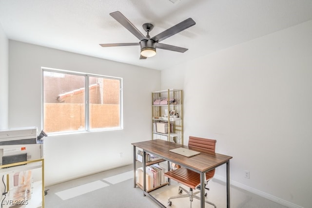 home office featuring baseboards, ceiling fan, and light carpet
