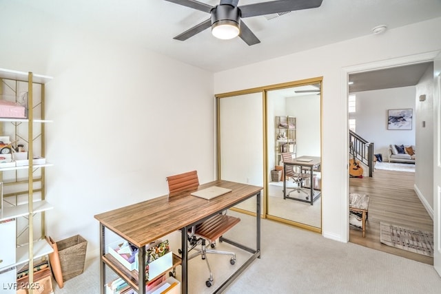 office space featuring ceiling fan and light carpet