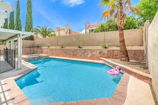 view of swimming pool with a fenced backyard and a pool with connected hot tub