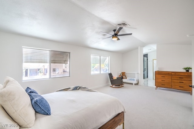 bedroom with carpet floors, ceiling fan, visible vents, and vaulted ceiling