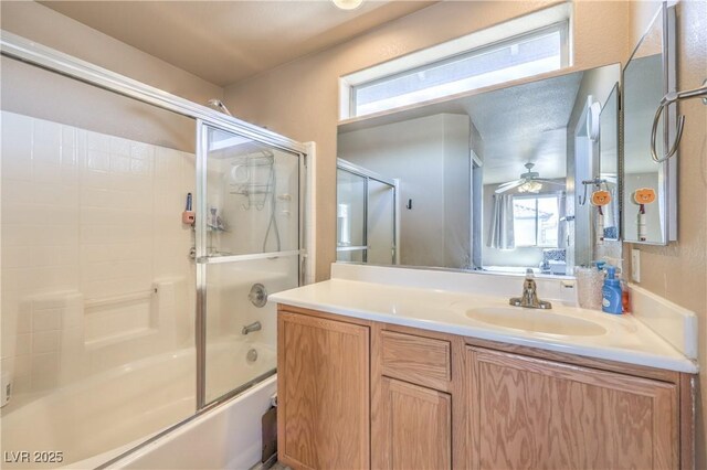 bathroom with a ceiling fan, combined bath / shower with glass door, a wealth of natural light, and vanity