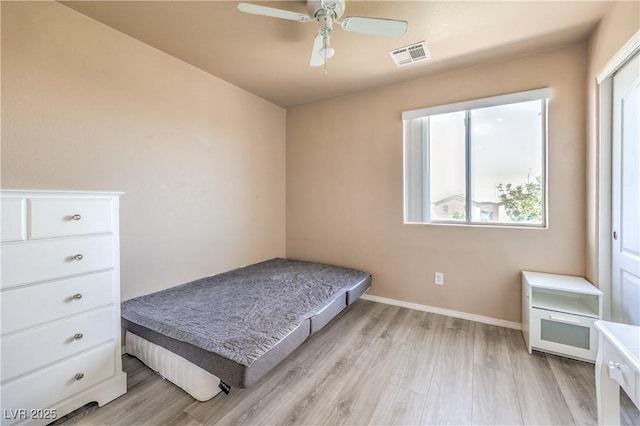 bedroom with baseboards, visible vents, ceiling fan, and light wood-style floors