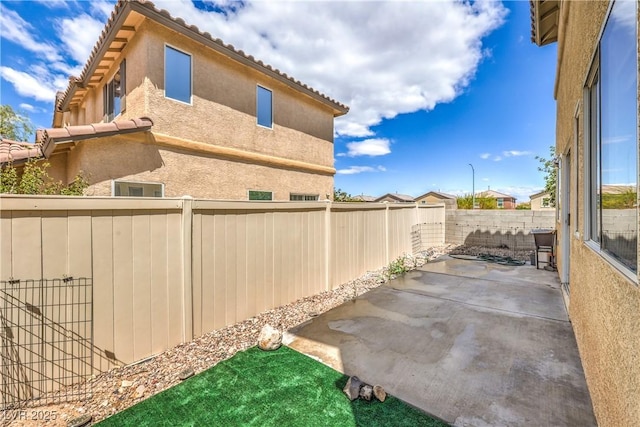exterior space with a fenced backyard and a patio area