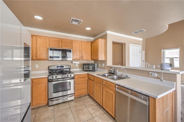 kitchen with stainless steel appliances, visible vents, a sink, and a peninsula