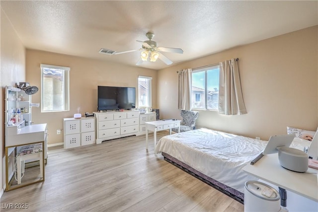 bedroom featuring ceiling fan, light wood finished floors, and visible vents