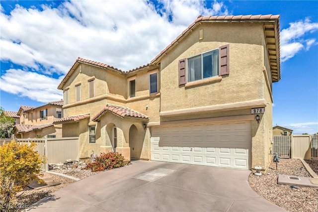 mediterranean / spanish house featuring an attached garage, fence, stucco siding, and driveway
