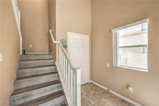 stairway featuring tile patterned flooring and baseboards