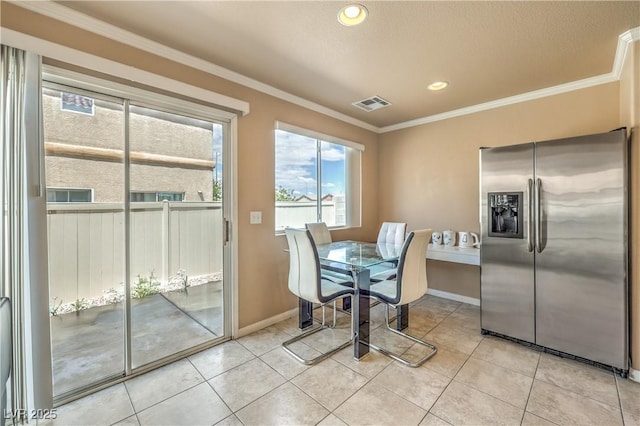 dining space featuring crown molding, baseboards, light tile patterned flooring, and visible vents