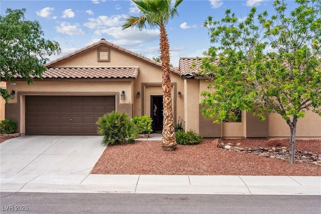 mediterranean / spanish-style home with stucco siding, driveway, a tile roof, and a garage