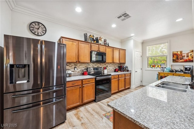 kitchen with black microwave, a sink, light wood-style flooring, electric stove, and stainless steel refrigerator with ice dispenser