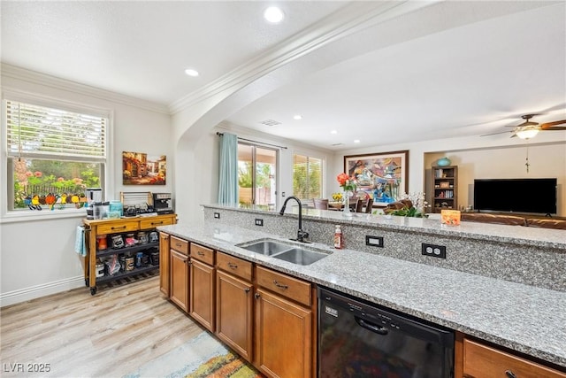 kitchen featuring a sink, light wood finished floors, arched walkways, black dishwasher, and ornamental molding