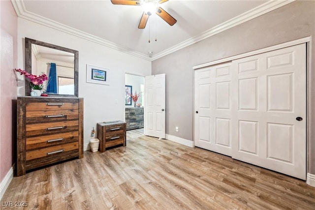 bedroom with baseboards, crown molding, wood finished floors, and a closet