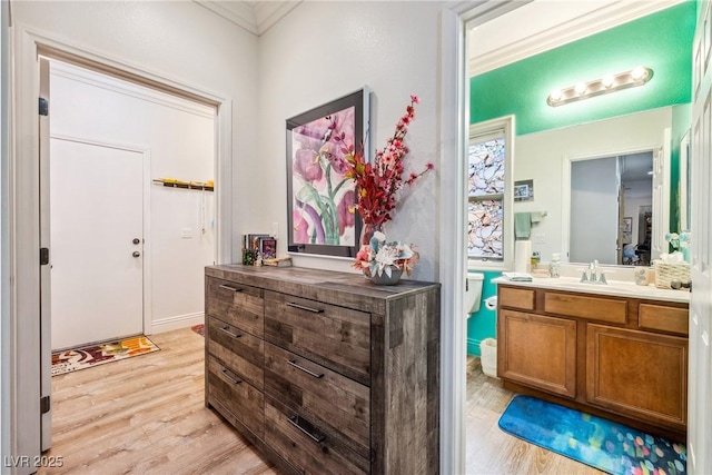 entryway featuring crown molding and light wood-style flooring