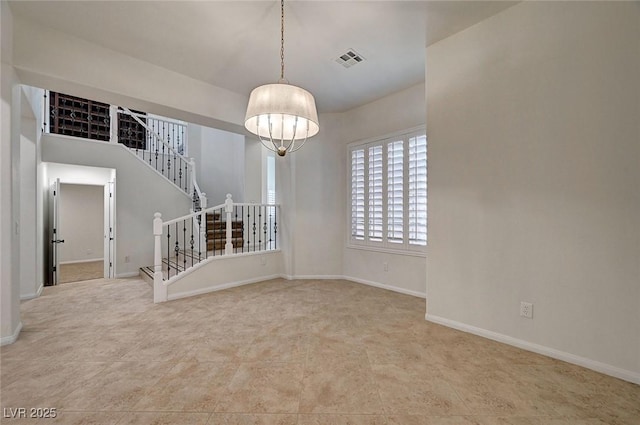 spare room featuring baseboards, stairs, and visible vents