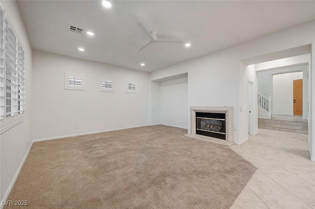 below grade area featuring a glass covered fireplace, a ceiling fan, recessed lighting, and visible vents