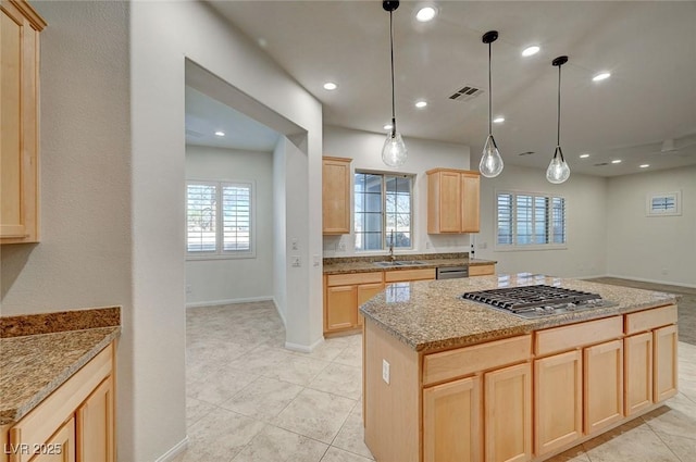 kitchen featuring visible vents, light brown cabinets, baseboards, a sink, and stainless steel appliances