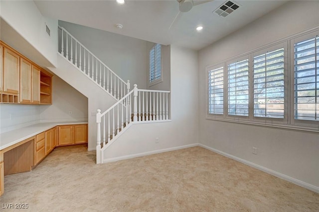 unfurnished living room with built in study area, a ceiling fan, recessed lighting, baseboards, and visible vents
