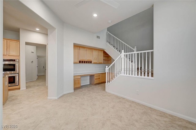 unfurnished living room with built in study area, baseboards, recessed lighting, light colored carpet, and a ceiling fan
