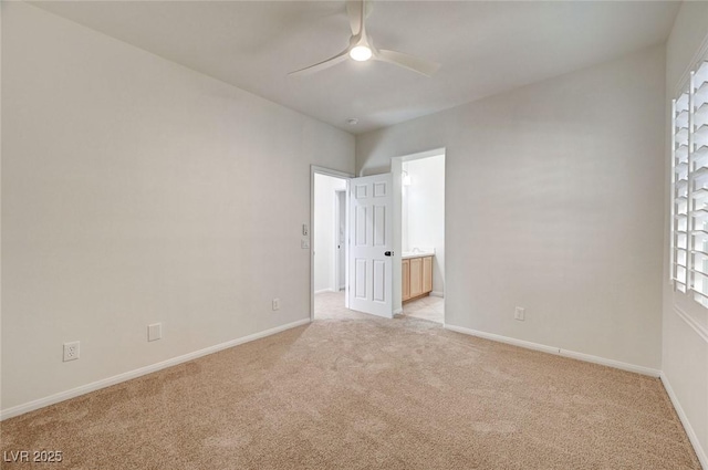 empty room featuring baseboards, ceiling fan, and light carpet