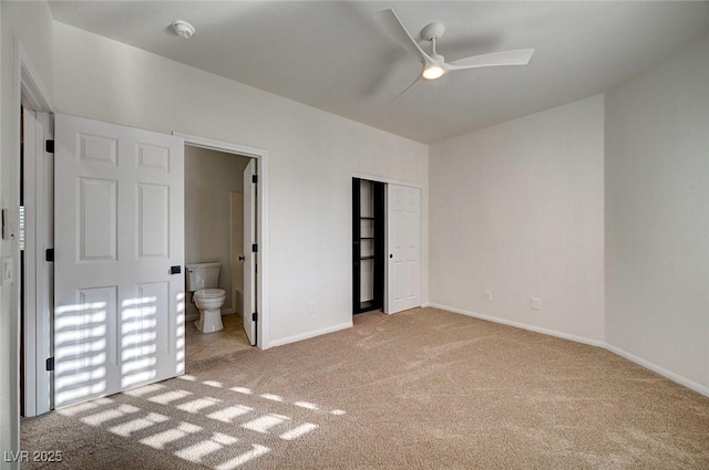 unfurnished bedroom with baseboards, light carpet, a closet, and connected bathroom