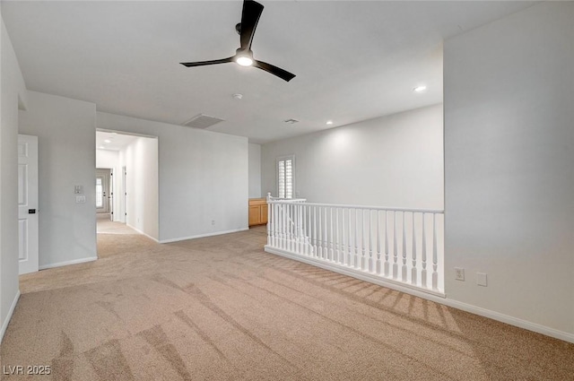 unfurnished room featuring baseboards, ceiling fan, visible vents, and light colored carpet