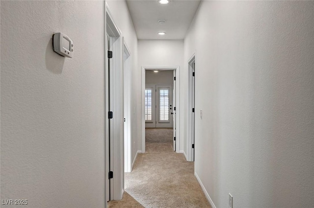 hall with recessed lighting, baseboards, and light carpet