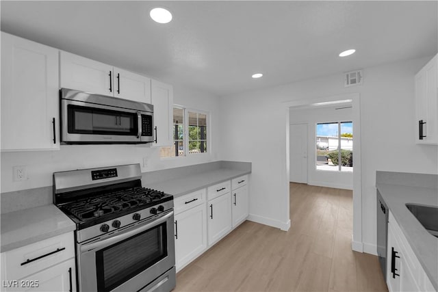 kitchen featuring visible vents, white cabinets, appliances with stainless steel finishes, and a wealth of natural light