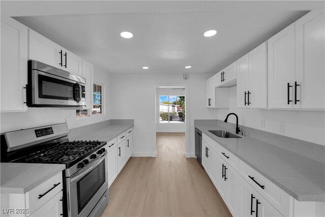 kitchen with light wood-style floors, baseboards, recessed lighting, a sink, and stainless steel appliances