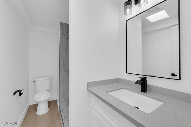bathroom featuring toilet, visible vents, wood finished floors, and vanity