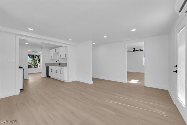 unfurnished living room with a ceiling fan, recessed lighting, a wall unit AC, and light wood-style floors