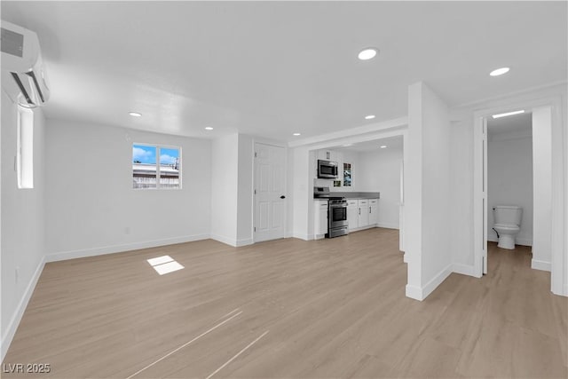 unfurnished living room featuring baseboards, recessed lighting, and light wood-style floors