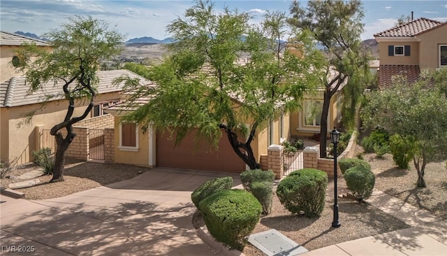 view of front of house featuring a garage, a mountain view, stucco siding, and driveway