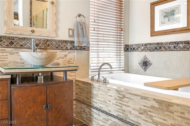 full bathroom featuring a garden tub, a wainscoted wall, vanity, and tile walls
