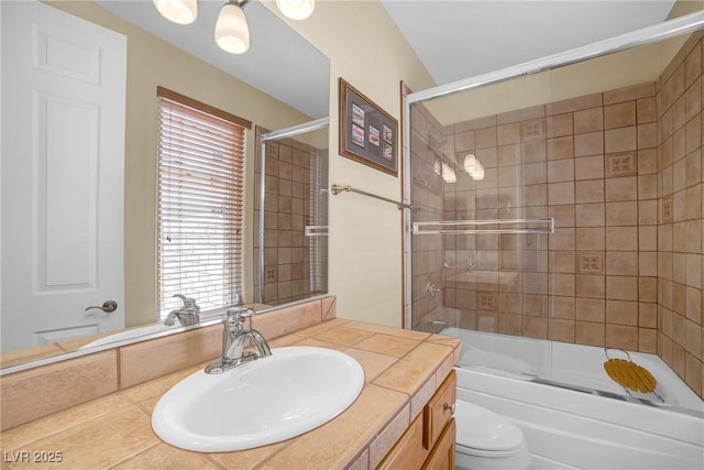 full bath with toilet, enclosed tub / shower combo, and vanity