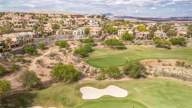 drone / aerial view with view of golf course, a mountain view, and a residential view