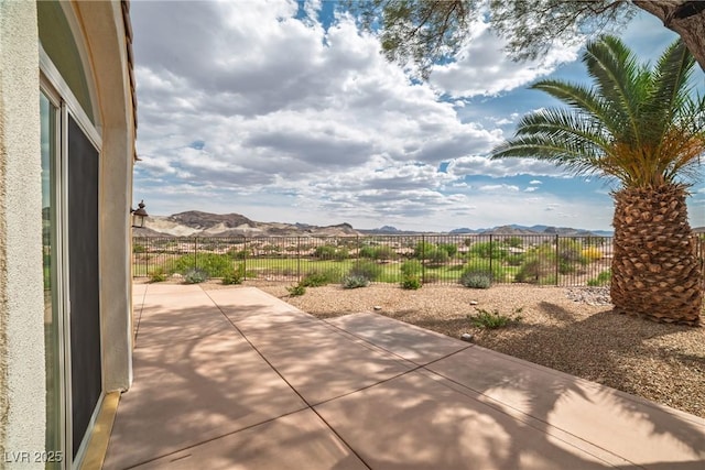 view of patio featuring a mountain view and a fenced backyard