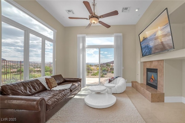 living area featuring visible vents, ceiling fan, tile patterned flooring, and a tile fireplace