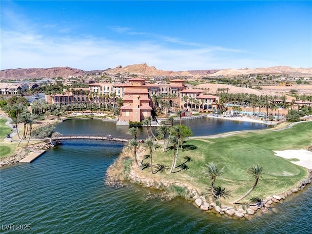 drone / aerial view with view of golf course and a water and mountain view